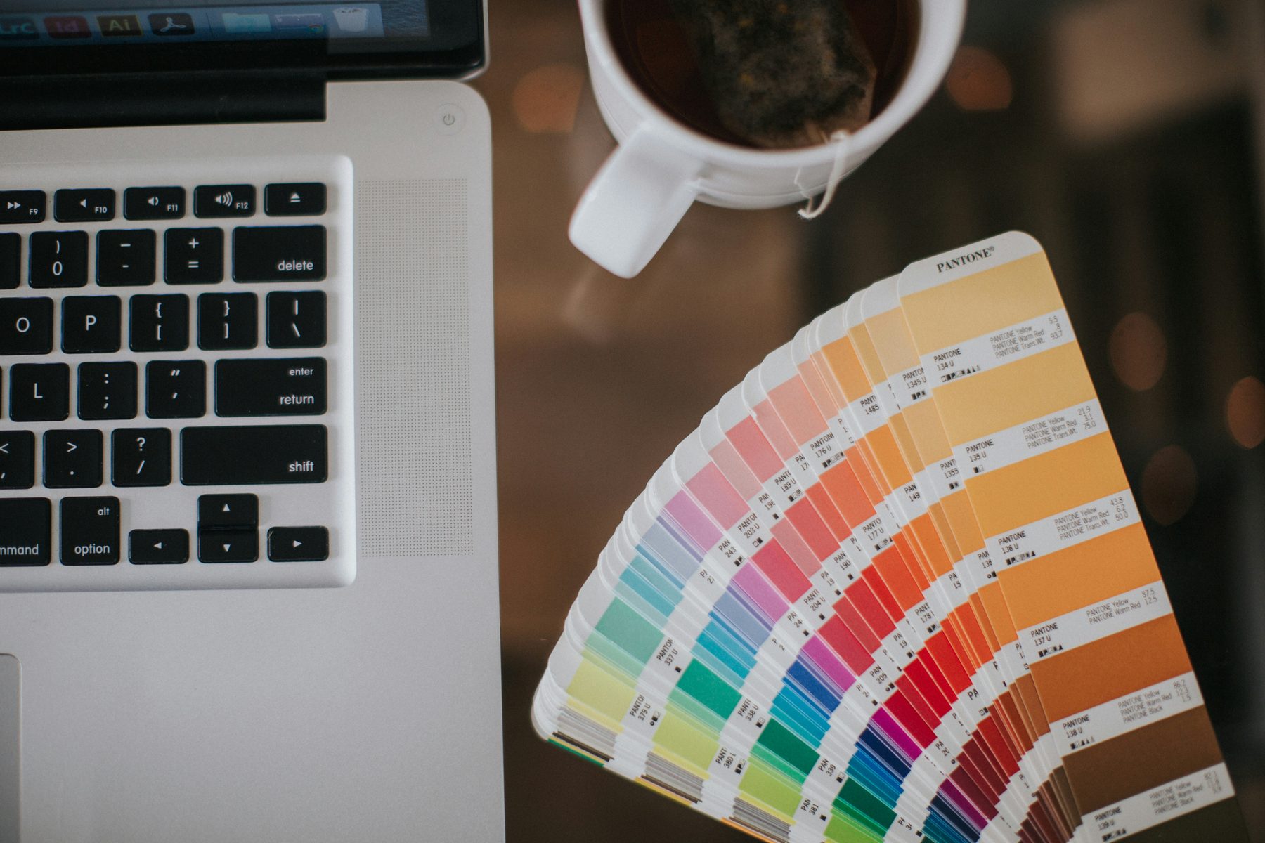Pantone color fan beside a design workstation